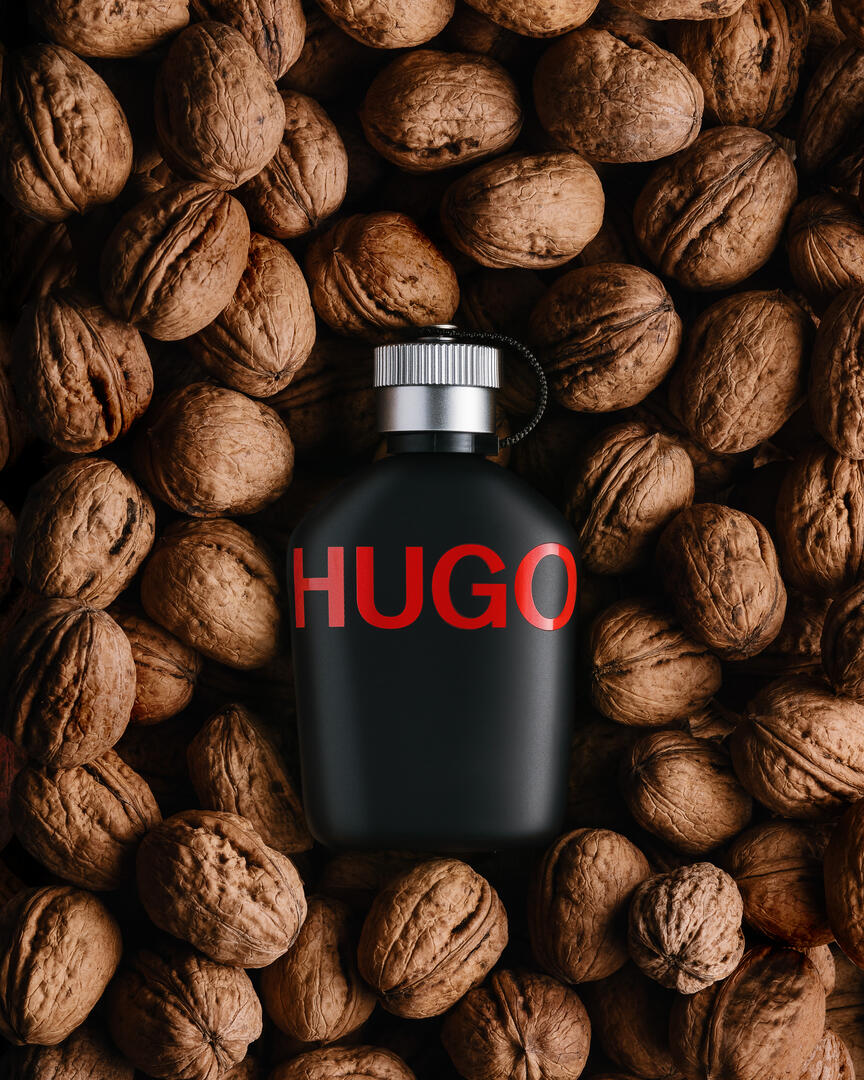 Hugo Boss парфюм с ядки. Мъжкият парфюм Hugo Boss лежи върху орехи. Поглед отгоре.