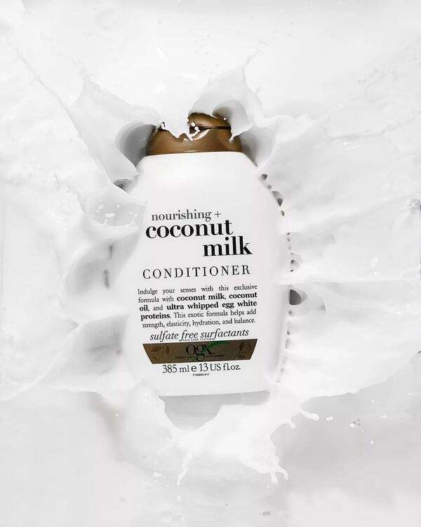 Nourishing Coconut Milk Conditioner - Ogx. Nourishing Coconut Milk Conditioner - Ogx. The bottle is falling into coconut milk. Splashes are everywhere!