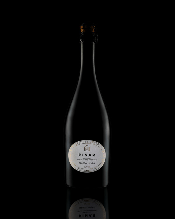 PINAR - Sparkling Cepage Pinot Chardonnay. PINAR - Sparkling Cepage Pinot Chardonnay. A bottle of alcohol-freed (0%) wine PINAR with shadows and reflection on a black background.