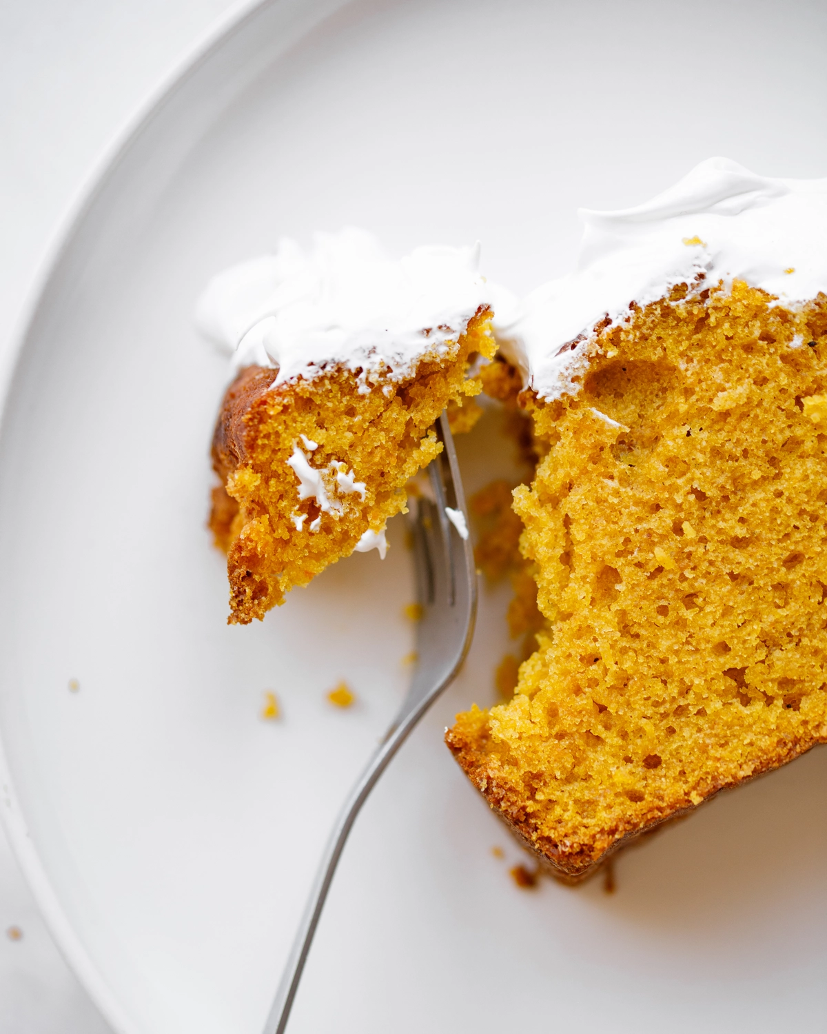 Pumpking bread cut lie on the plate. There are 2 slices of pumpkin bread on the plate. Its delicate texture and delightful orange color are visible.