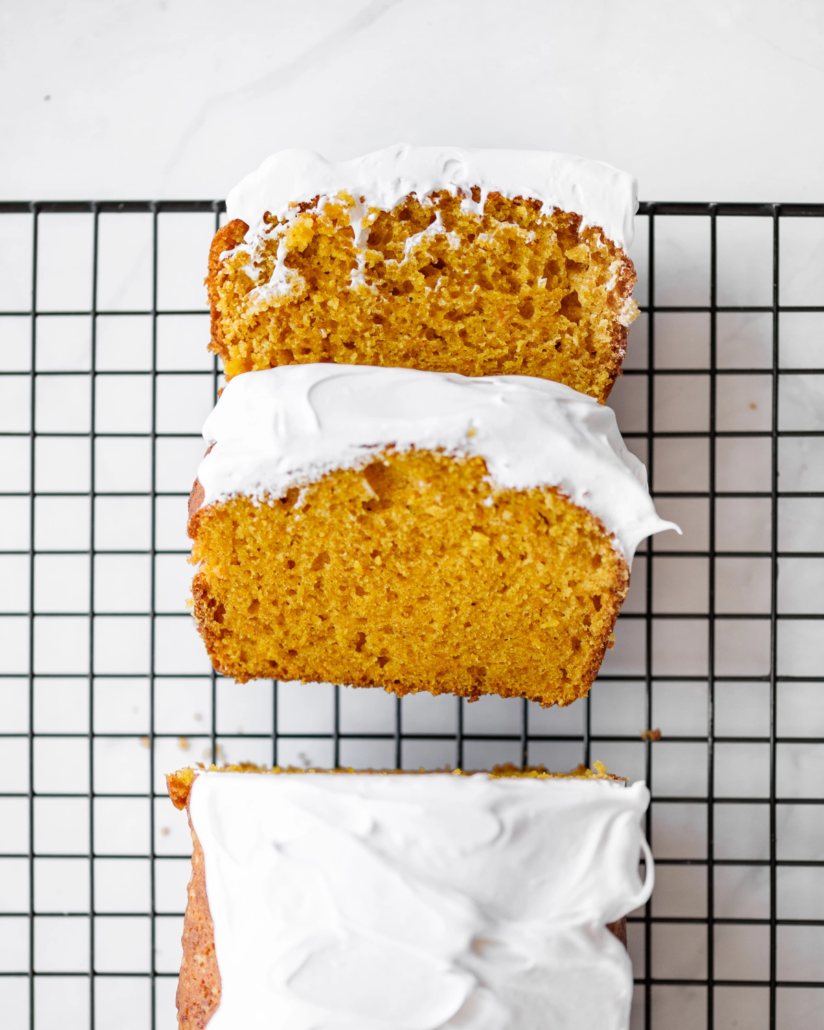 Pumpking bread cut. There are 2 slices of pumpkin bread cut from full bread - they lie on the lattice. Its delicate texture and delightful orange color are visible.