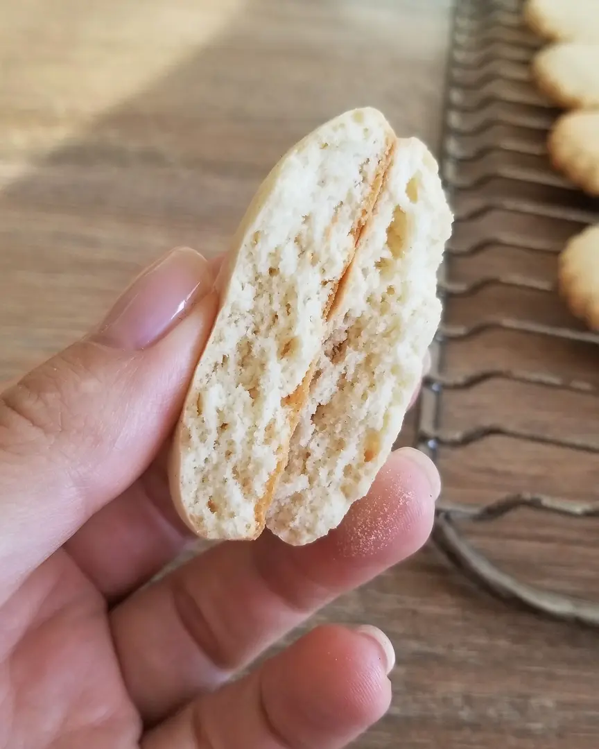 текстура на бисквитката вътре. Женска ръка, държаща бисквитка, показва текстурата на бисквитката вътре.