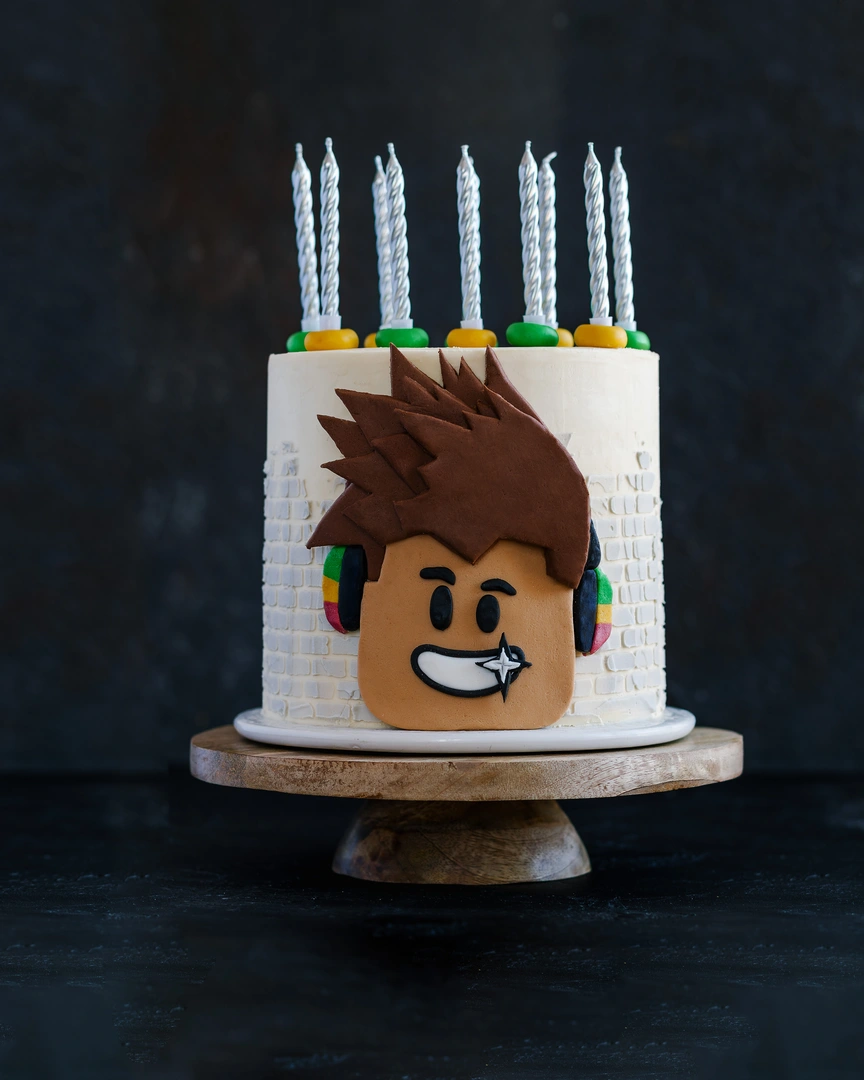 Крем за торта за покриване. На тъмен фон - е керамична стойка стои торта, украсена със свещи. На повърхността на тортата като декор се използва снимка на усмихнат млад мъж.