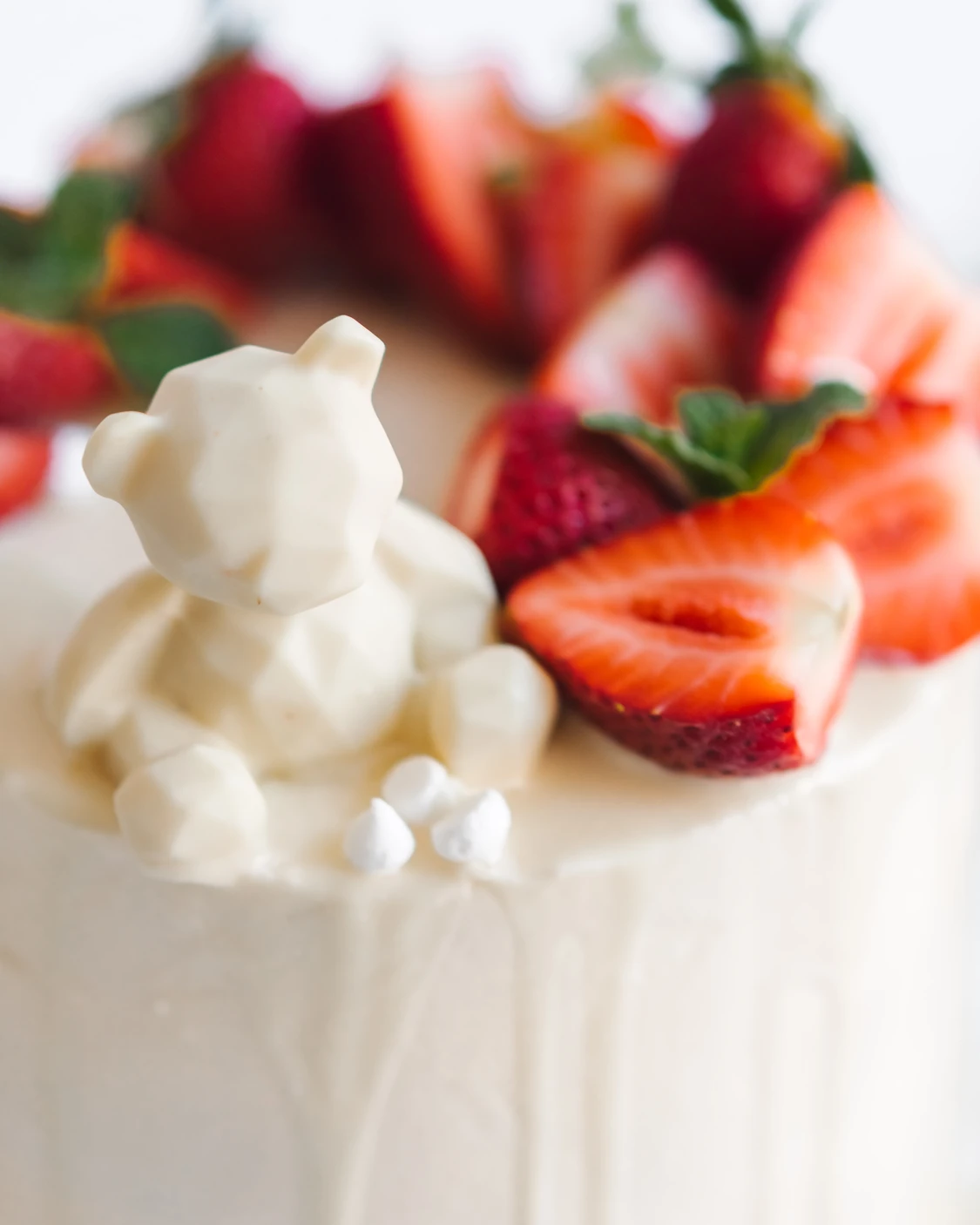 A chocolate bear is placed on the cake surface. A chocolate bear is placed on the surface of the cake.
The cake is decorated with fresh strawberries.