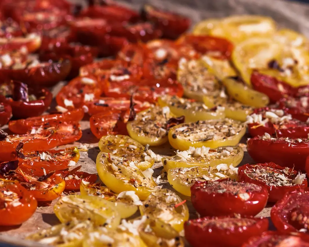 Сушени чери домати. Сушени чери домати, покрити с подправки и сол, за да изсъхнат под жаркото слънце.
