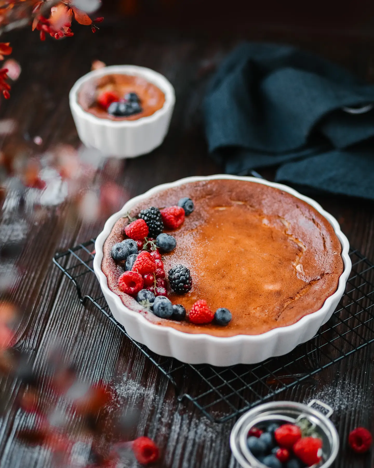 Cottage cheese casserole A sweet cottage cheese pie stands on a dark wooden background. It is decorated with berries and powdered sugar.