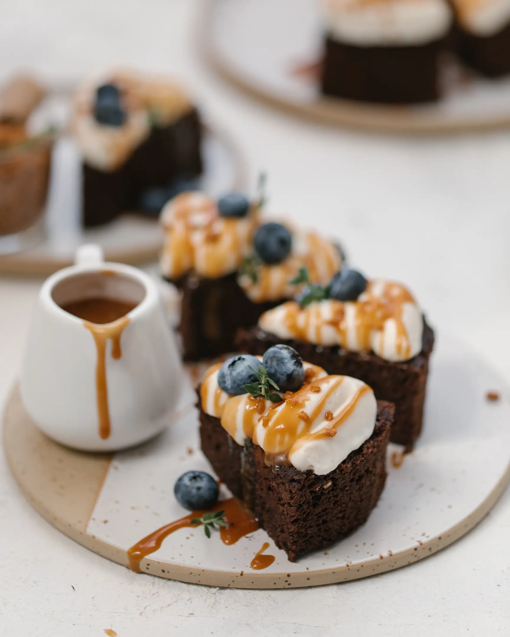 The chocolate-banana cake is on a plate .  Chocolate banana cupcake with buttercream and berries. The cake is on a plate and cut into portions. View from above.