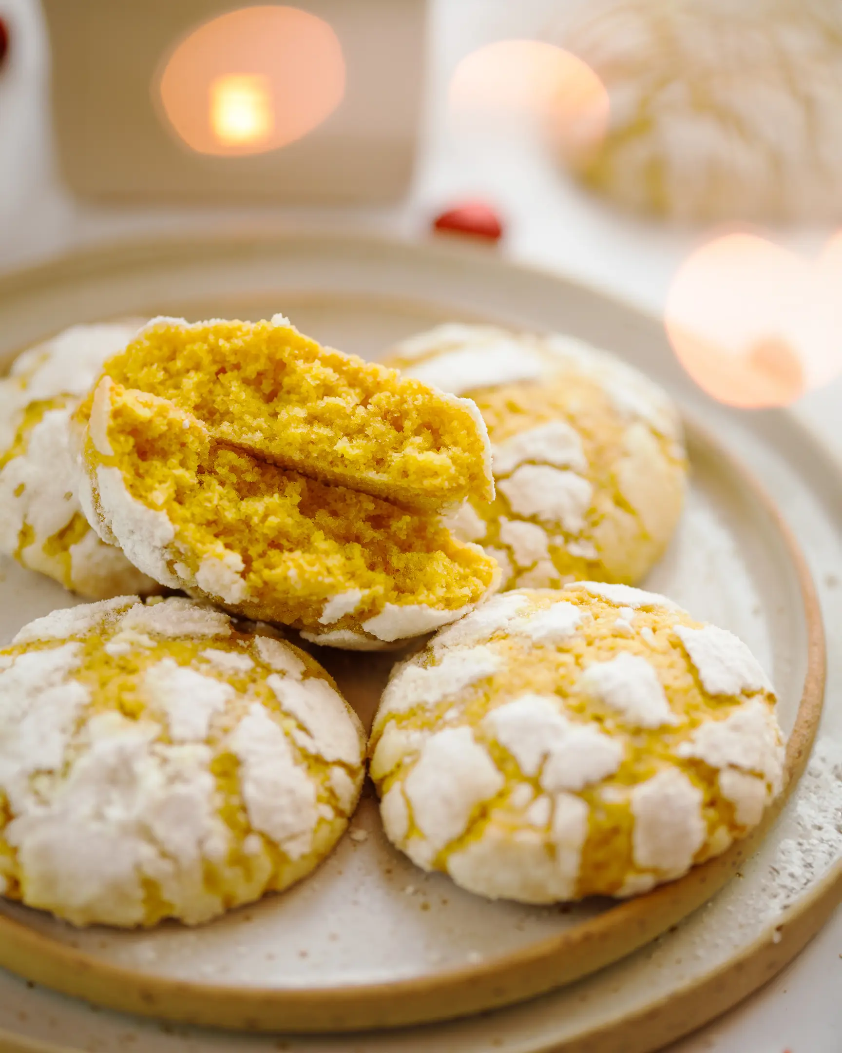 Cookies with cracks are cut.  Cookies with cracks are cut. They are on a plate. Texture visible. The lights from the Christmas tree are visible in the foreground.