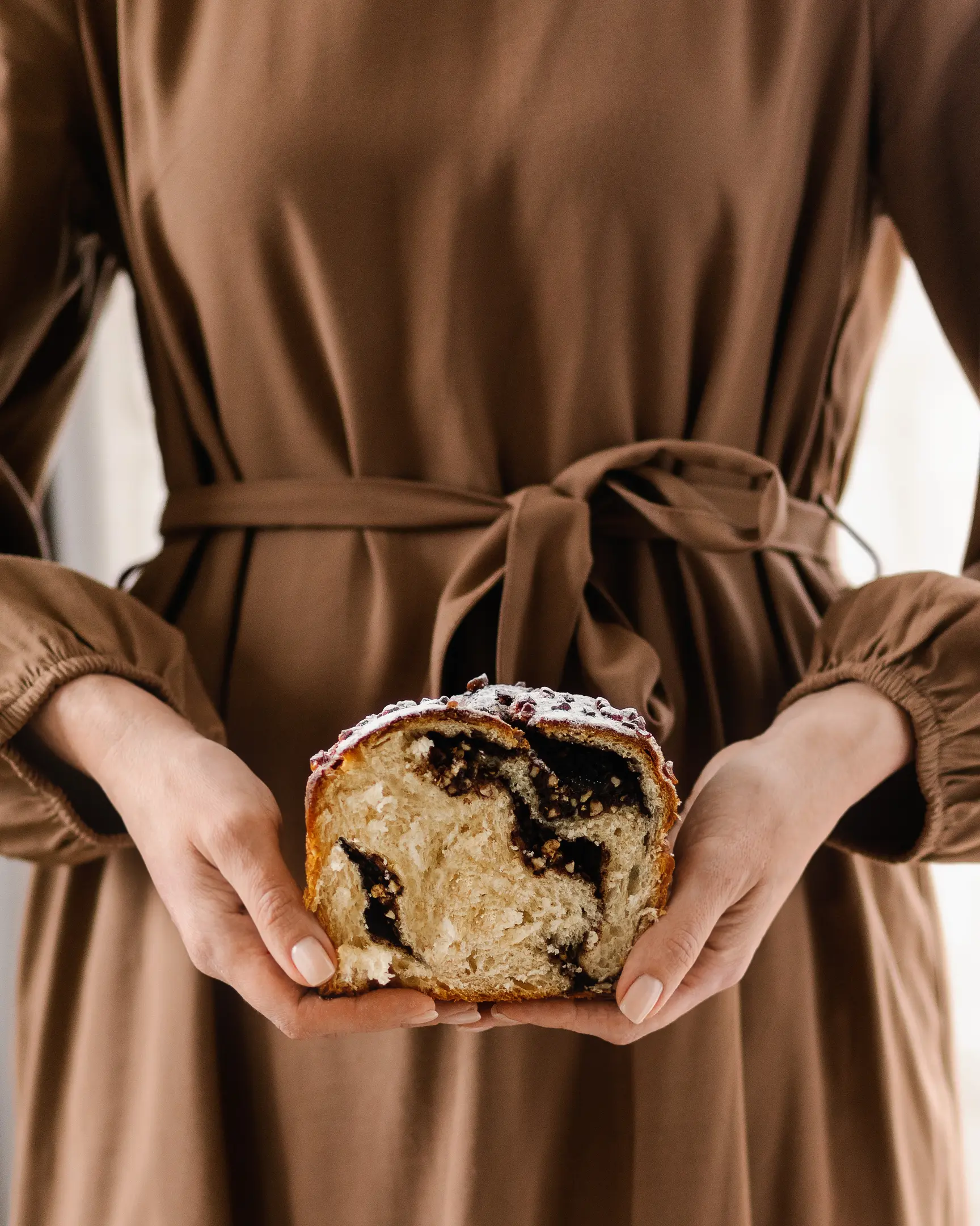 A woman is holding in her hands Easter bread.   A woman is holding in her hands Easter bread.  The viewer can see the texture of the bread.