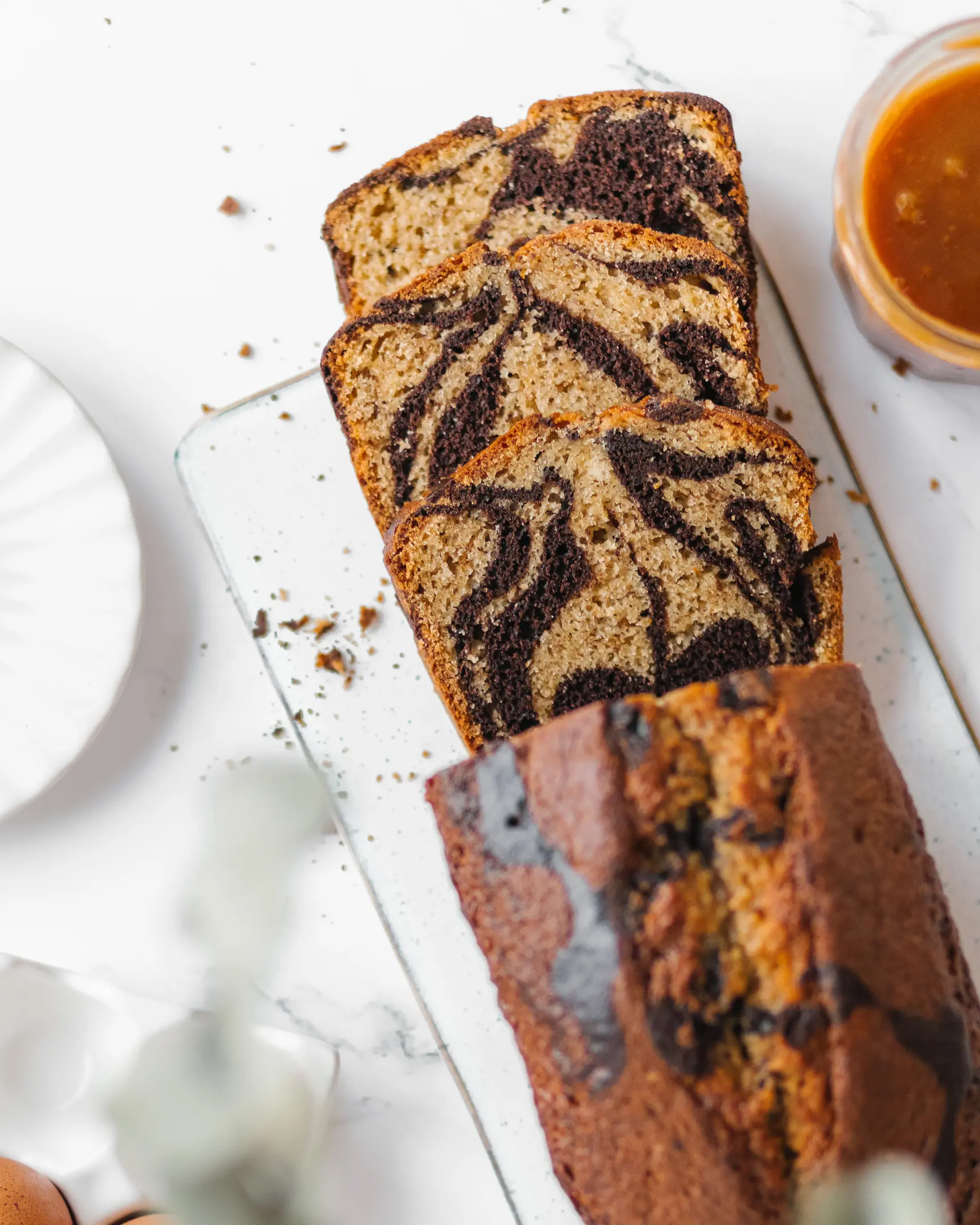 A sliced marble cake lies on a pastry rack to cool. A sliced marble cake lies on a pastry rack to cool.