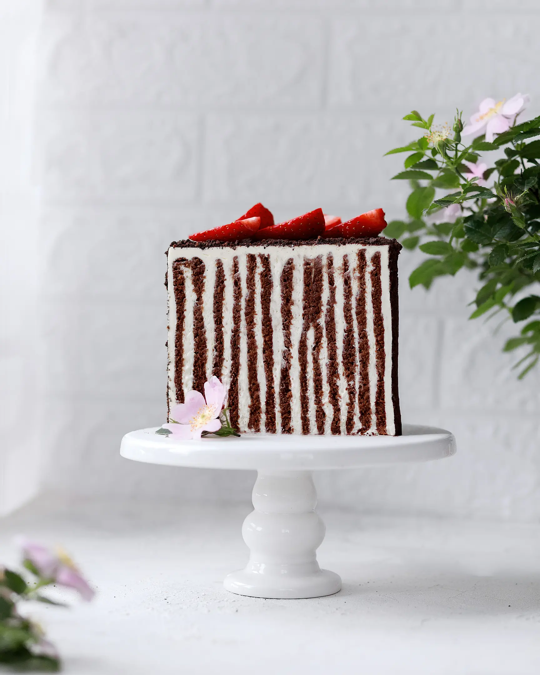 Вертикален разрез на шоколадова медена торта. Медената питка се разрязва. Зрителят може да види слоевете на тортата. Тортата стои на стойка на фона на витрината.