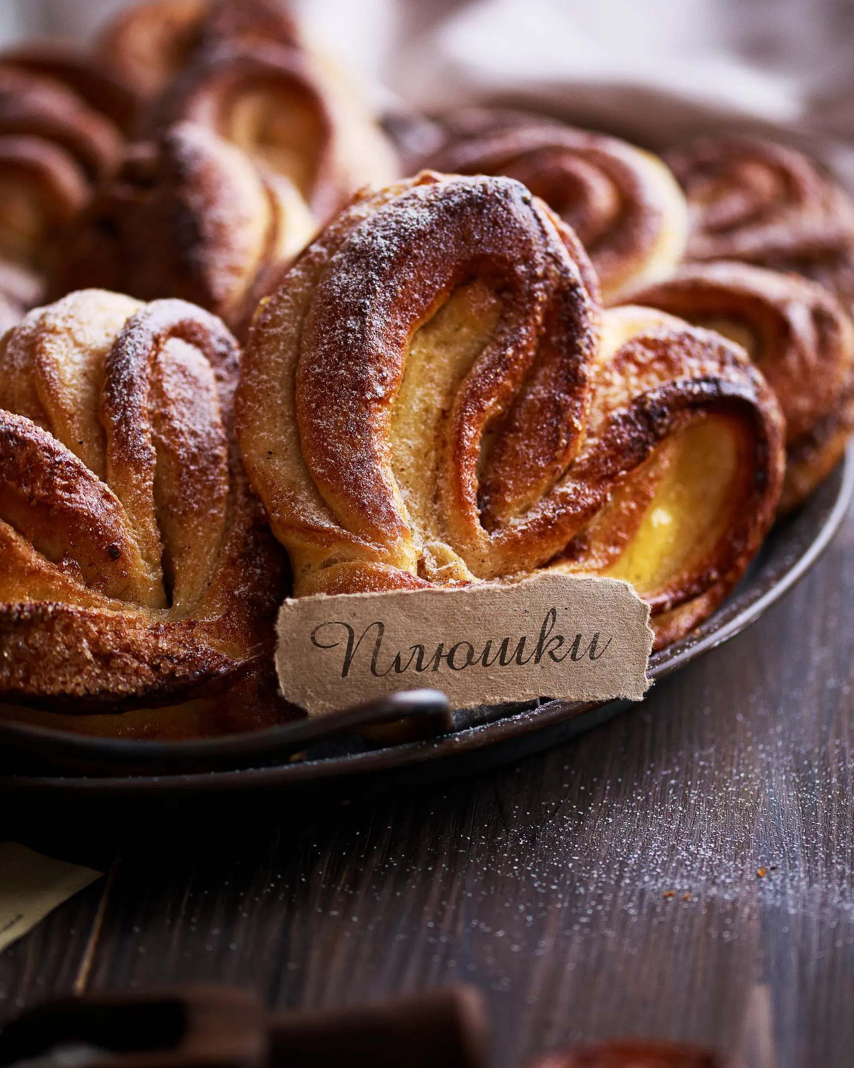 Heart-shaped buns lie on  a large metal plate. Heart-shaped buns lie on a wooden table on a large metal plate. Cinnamon Sugar Rolls.