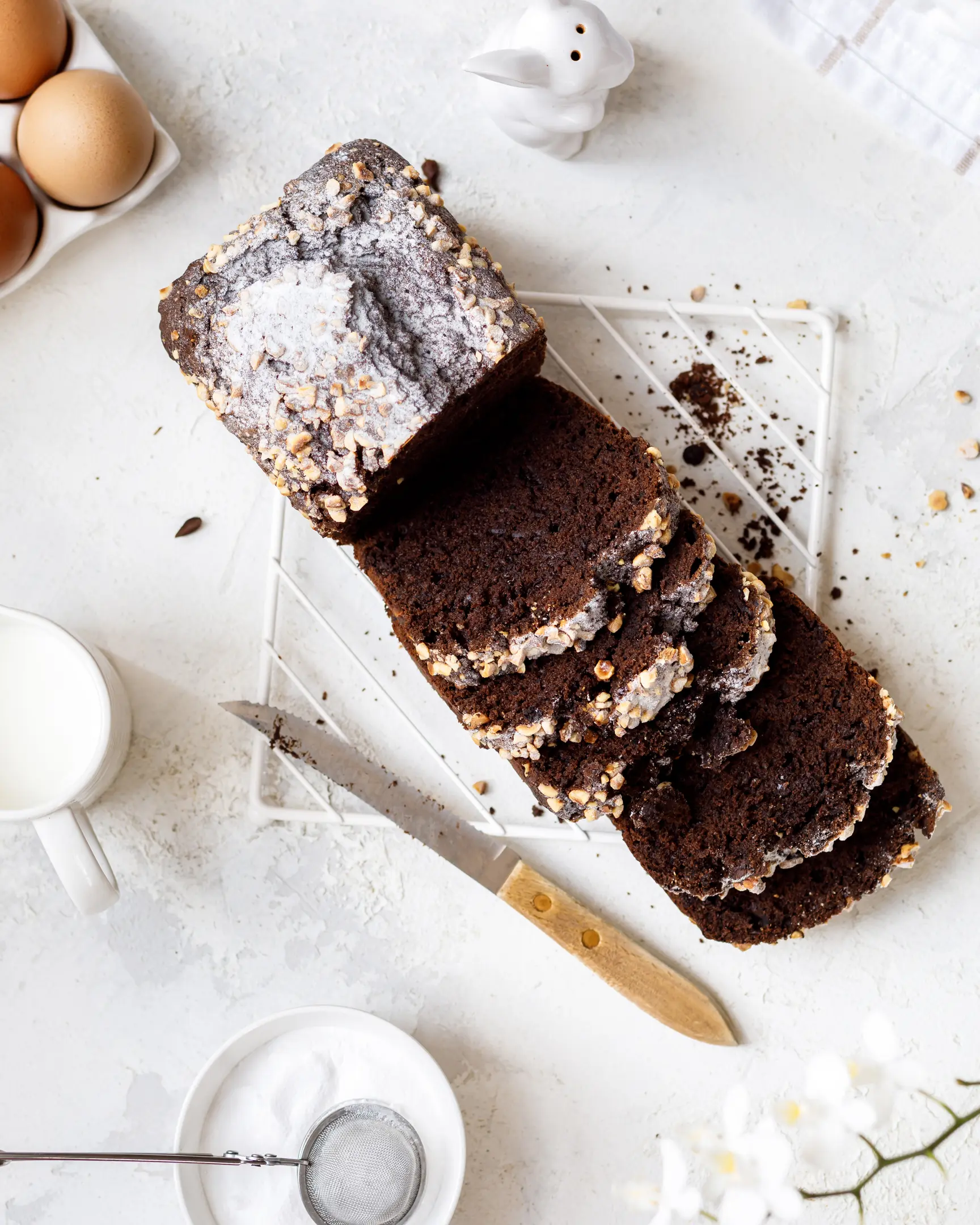 There is a chocolate banana cupcake on the table.  There is a chocolate banana cupcake on the table. It's cut. View from above. The texture of the cake is visible.