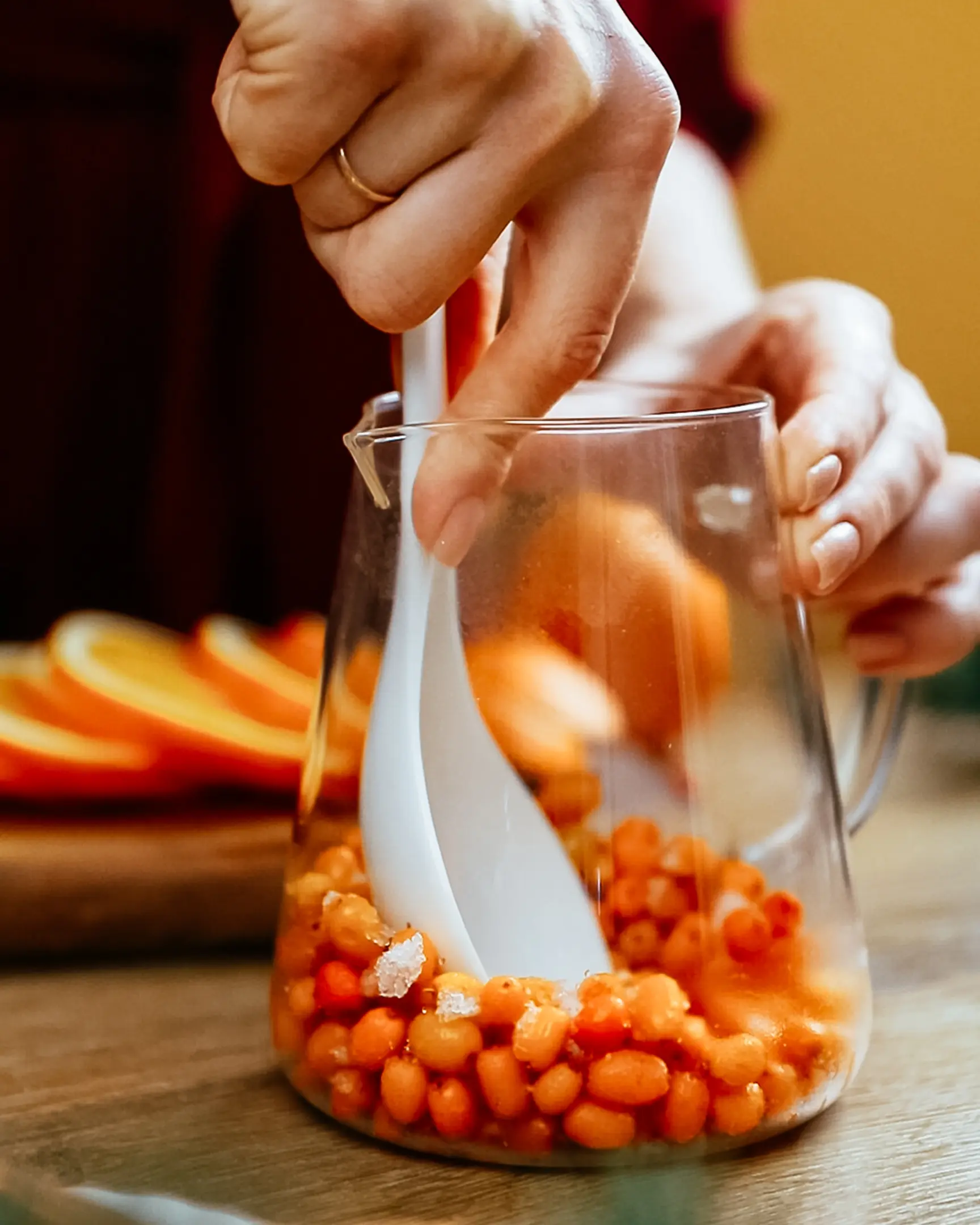 Woman crushes sea buckthorn with a spoon Woman crushes sea buckthorn with a spoon