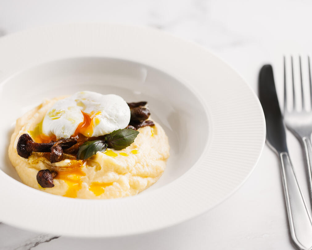 On a plate is mashed cauliflower. On a plate is mashed cauliflower garnished with mushrooms and a poached egg.