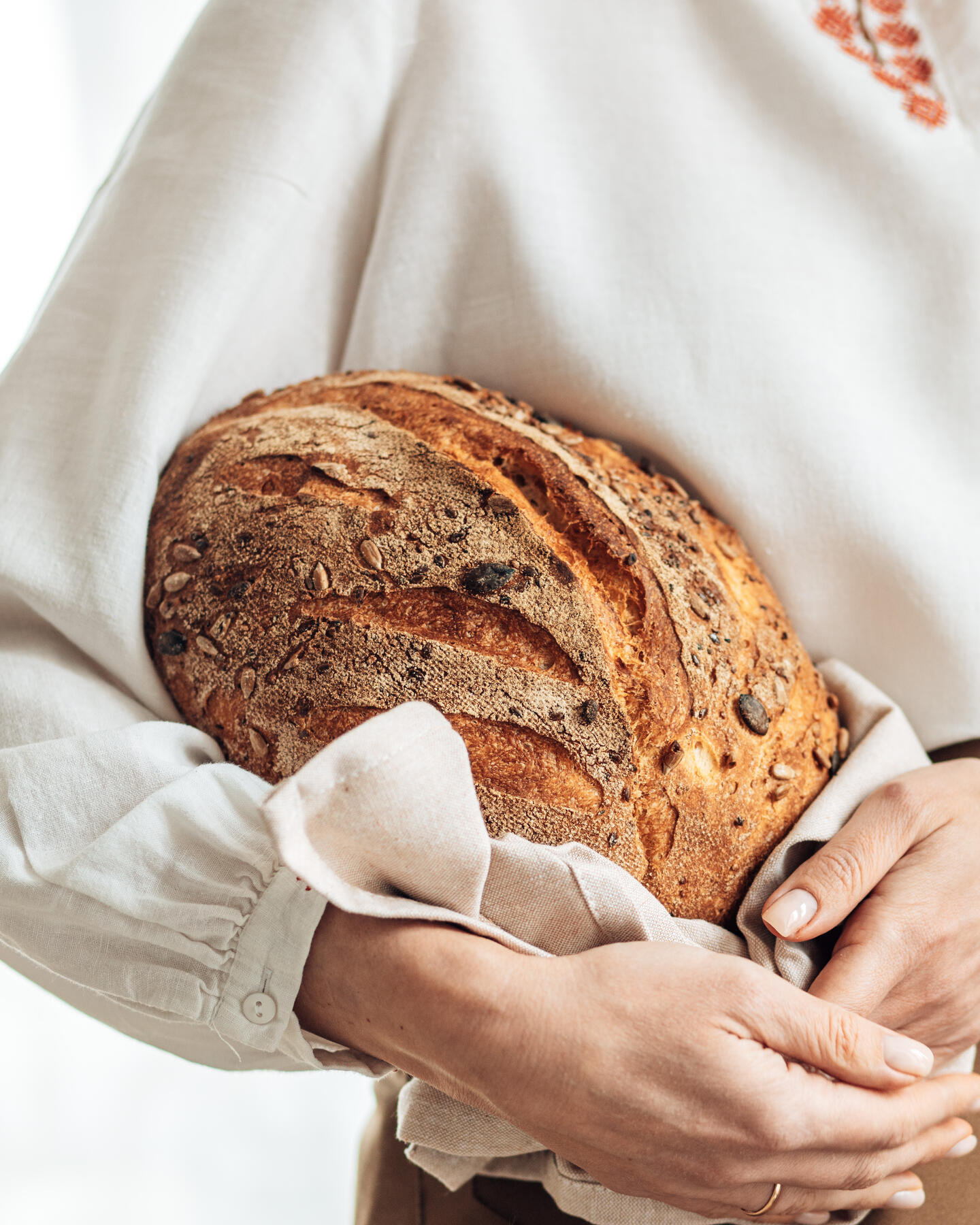 A woman holding the bread in her hands. A woman holding the bread in her hands.