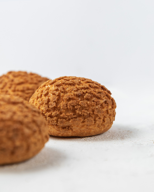 Round eclairs. Round eclairs are in the center of the photo with a white background.