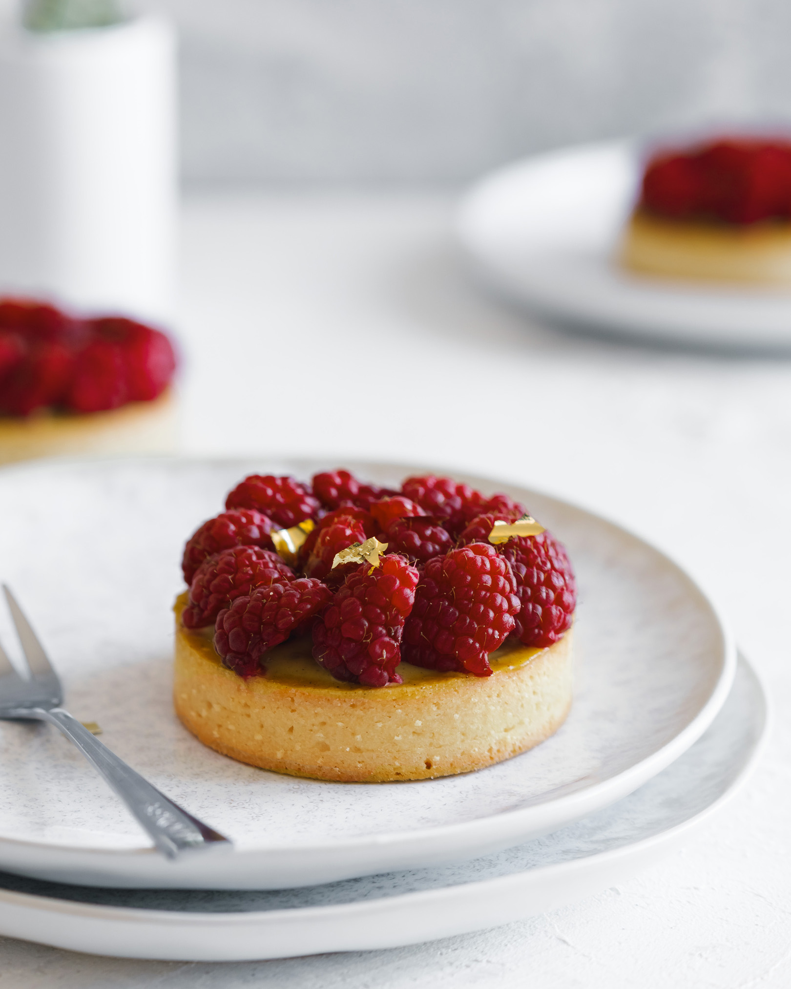 Tartlets with hazelnut cream. Tartlets with hazelnut cream, decorated by raspberries and gold.