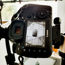 Shooting. Shooting. A professional photo camera, surrounded by different props, is shooting a product.