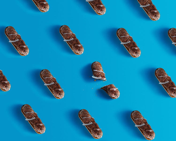 A pattern made of eclairs. On a blue background, some eclairs form a pattern.