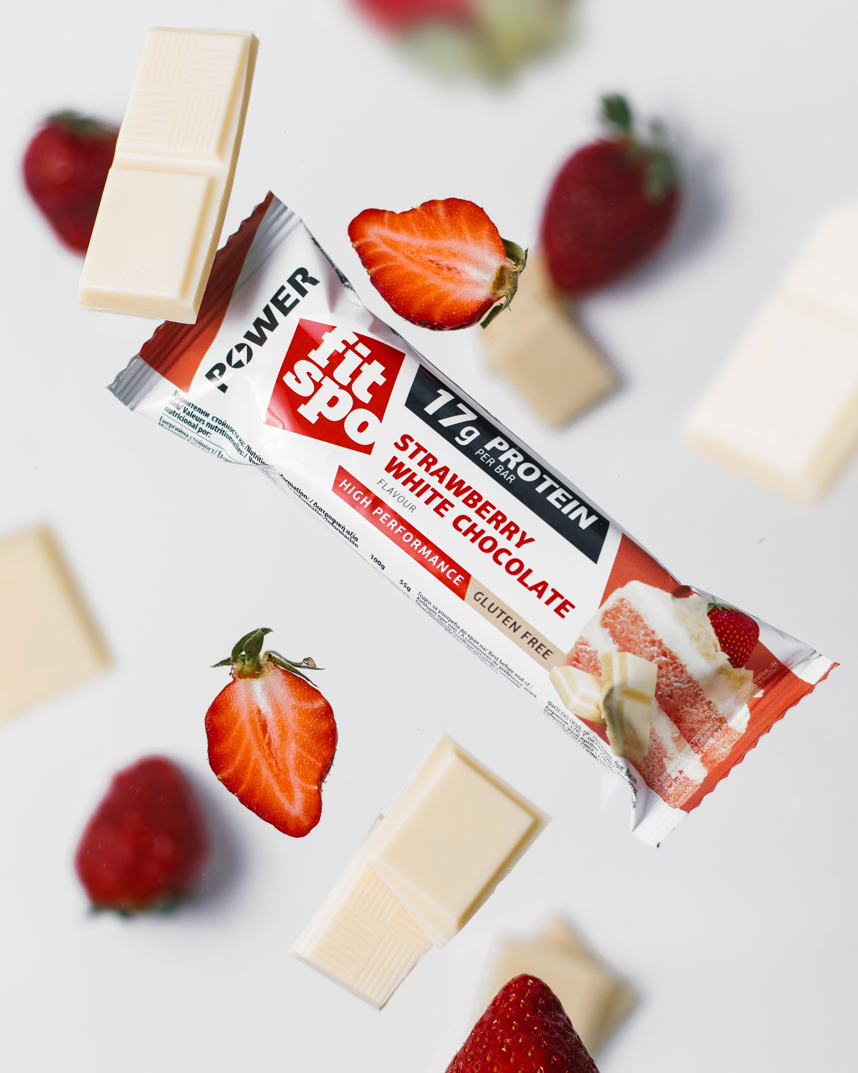 FitPro bar in free fall flies among strawberries and chocolate pieces. Fitpro bar in free fall flies among strawberries and chocolate pieces